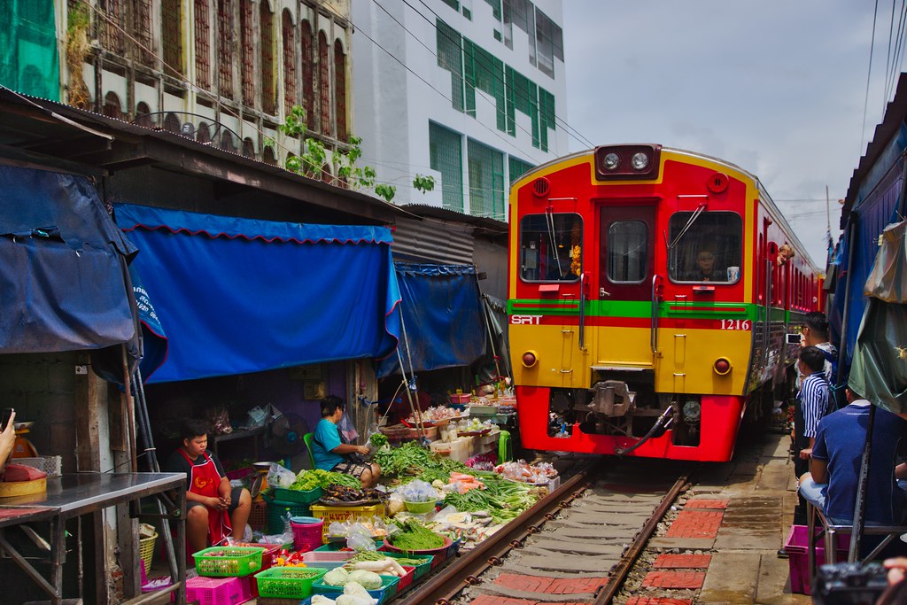 Mae Klong railway market with passing train in Samut Songkhram province in Thailand